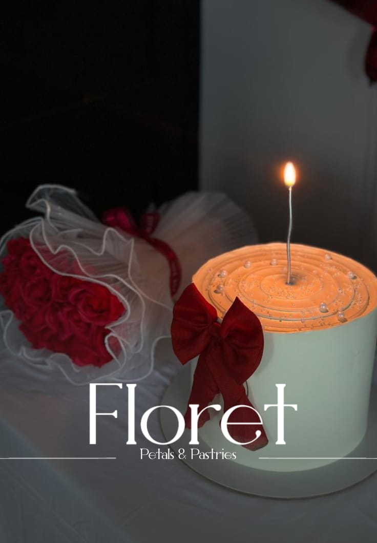 Petals and Pastries bouquet — Cherry-red roses in tulle with a pearl-dotted ivory cake and a single wish-it candle