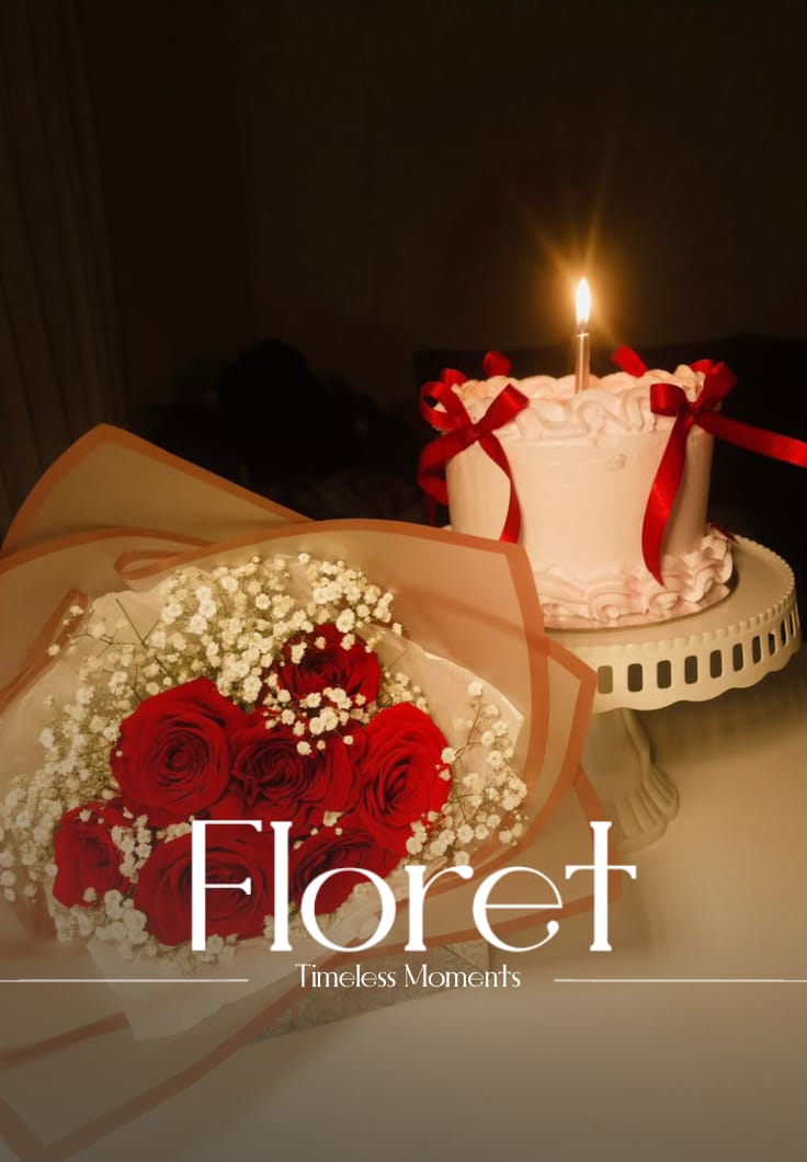 Timeless Moments bouquet — Red roses in a baby's breath halo, beside a ribbon-wrapped blush cake on a pedestal